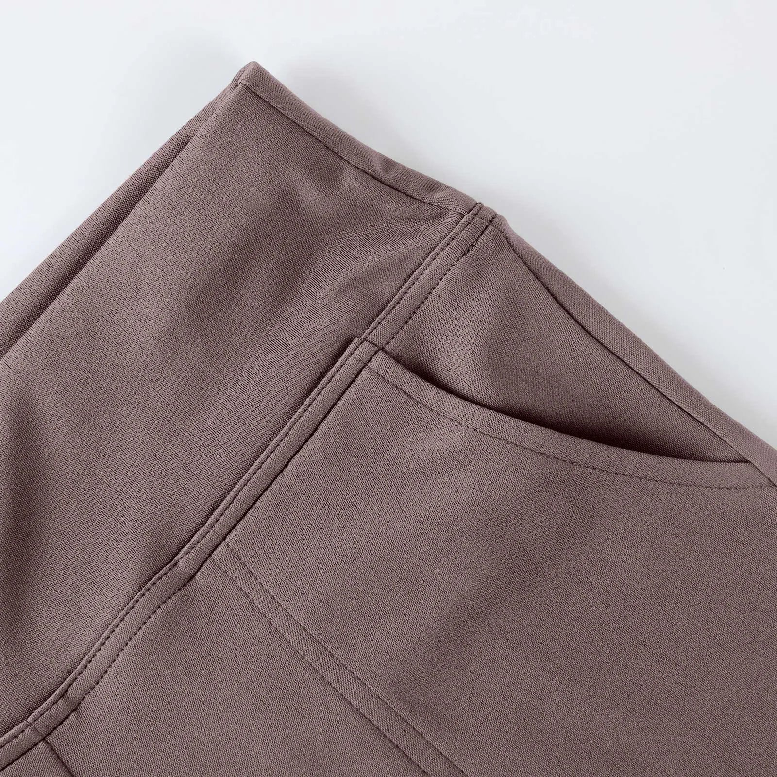 Close-up of taupe stretch fabric pants with stitched pocket detail