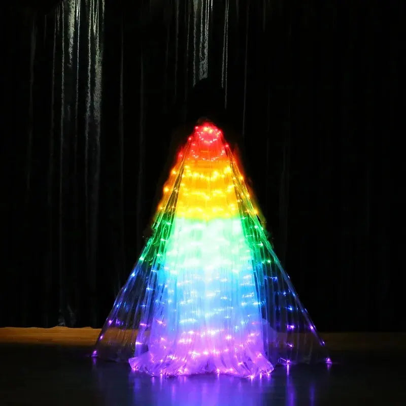 Person wearing illuminated LED rainbow light-up cape costume on stage in dark setting