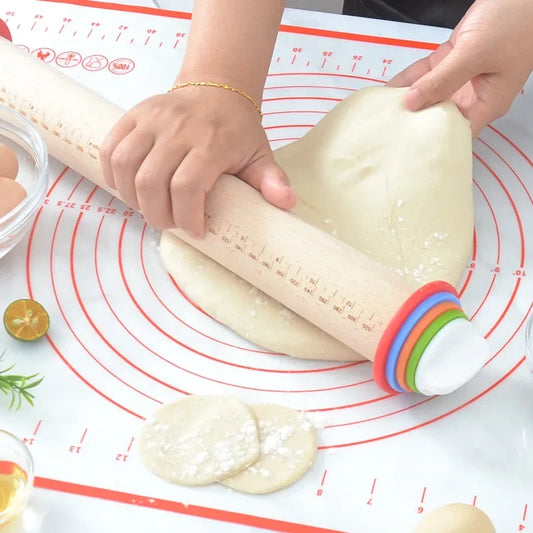 Adjustable rolling pin with measurement rings flattening dough on a non-stick baking mat