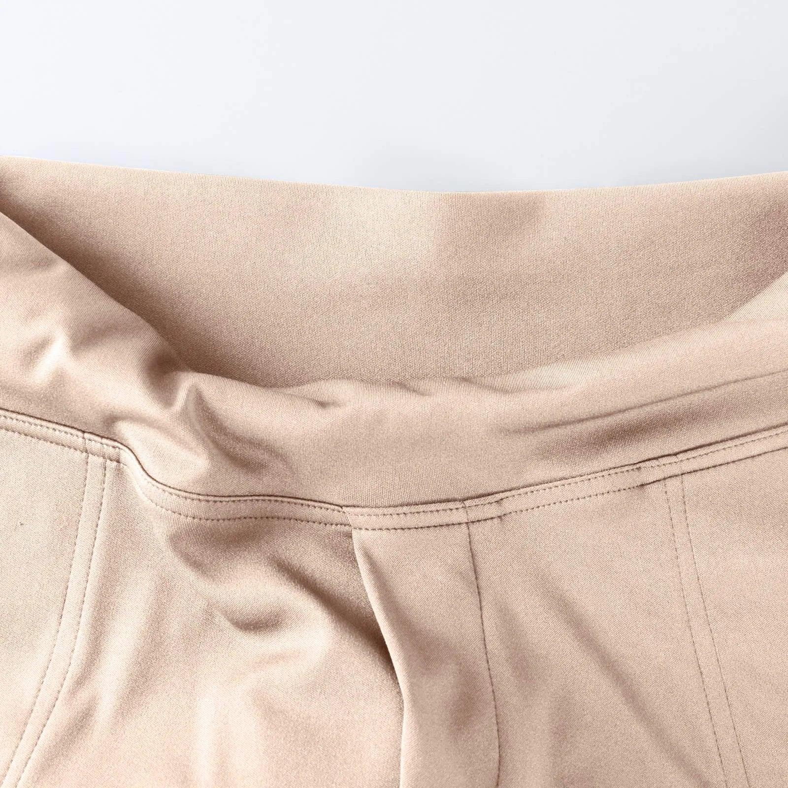 Close-up of beige high-waisted pants with soft stretch waistband and visible stitching