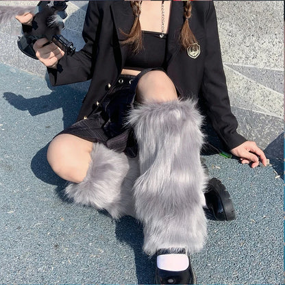 Person sitting outdoors wearing gray faux fur leg warmers, black skirt, and black jacket