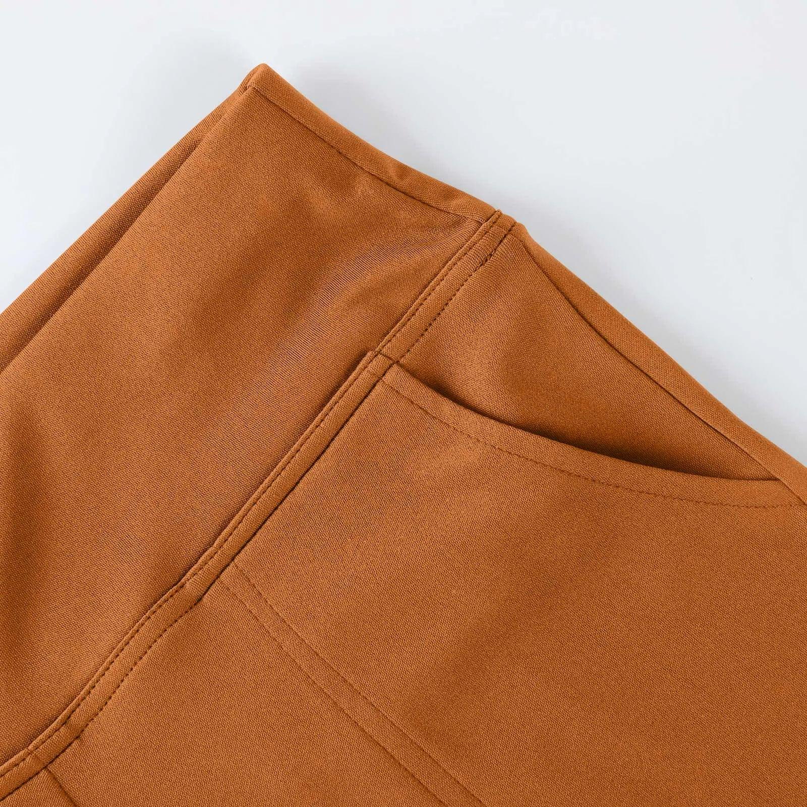 Close-up of brown fabric pants pocket with visible stitching on a flat surface.