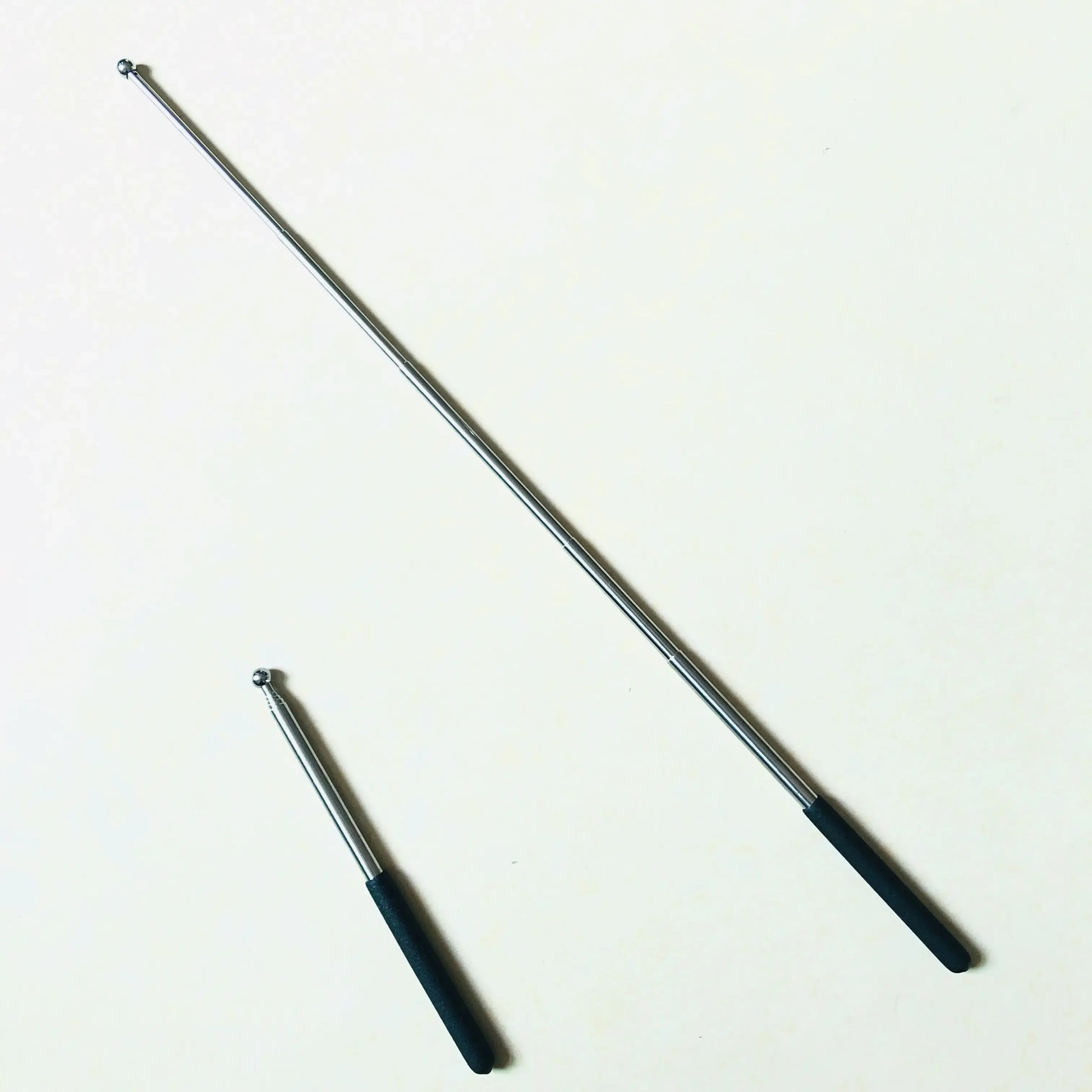 Telescopic metal pointer with black handle, shown extended and retracted on white background