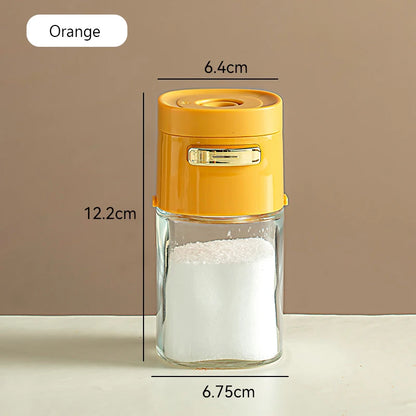 Orange-lidded glass spice container with gold clasp, 12.2cm tall, on a neutral background