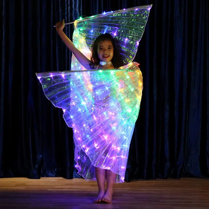 Child wearing illuminated LED light up butterfly wings costume on stage with dark curtain backdrop