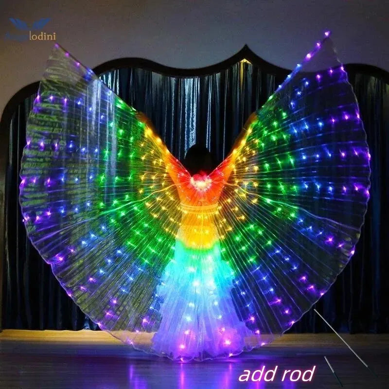 Person wearing illuminated LED rainbow wings costume in a dark room with curtain backdrop