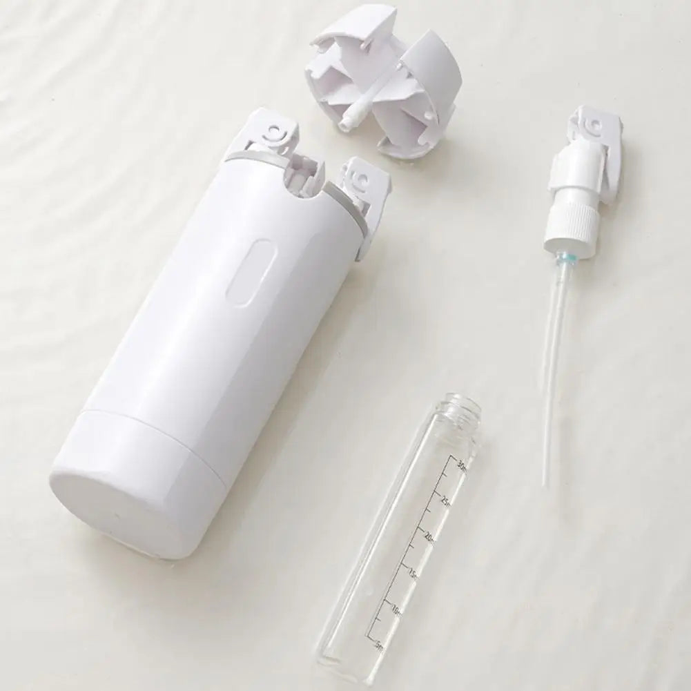 Disassembled white spray bottle set with clear measuring tube and pump on light background