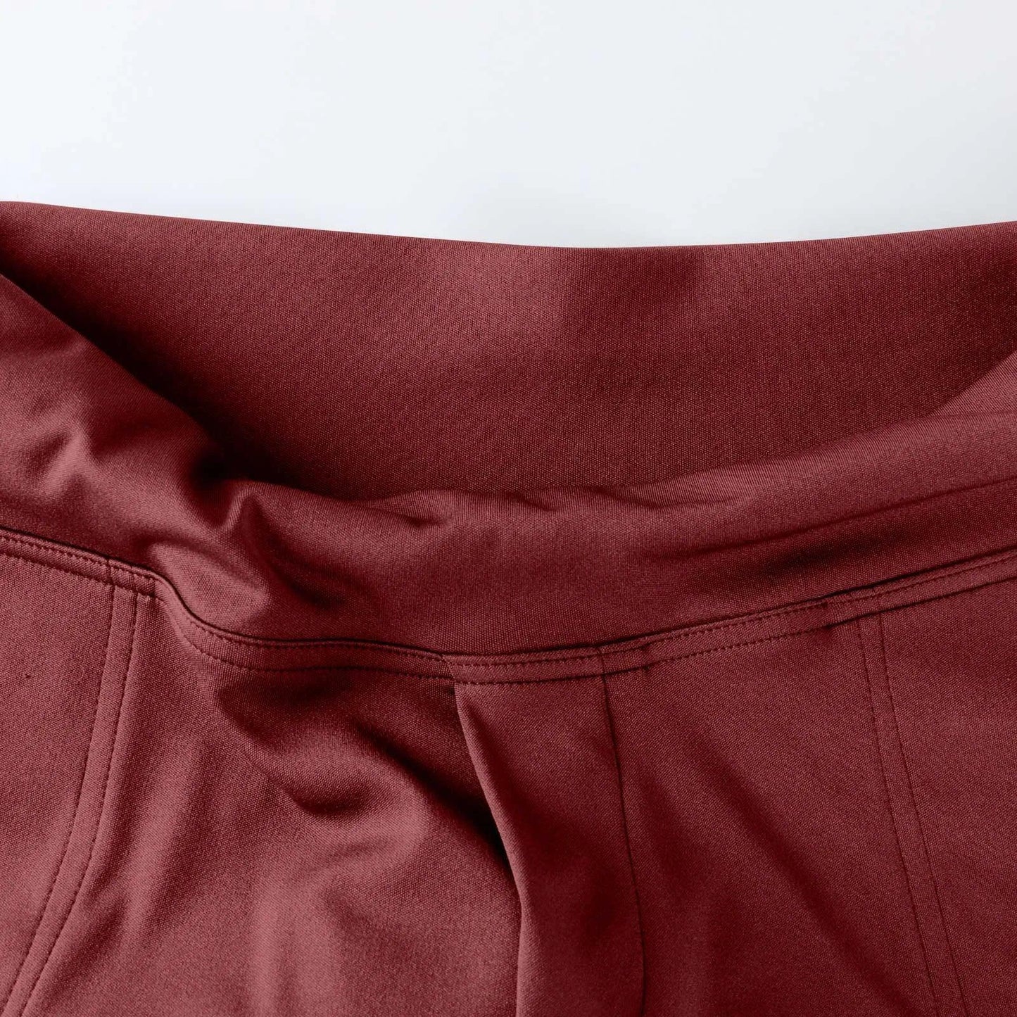 Close-up of maroon high-waisted leggings waistband with flatlock stitching
