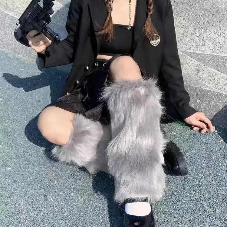 Woman in streetwear outfit with gray faux fur leg warmers and black mini skirt sitting outdoors