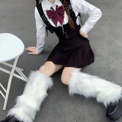 Person in black skirt, white shirt with maroon bow, and white furry leg warmers sitting on ground