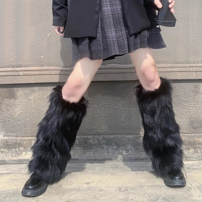 Person wearing black faux fur leg warmers with plaid skirt and black shoes outdoors