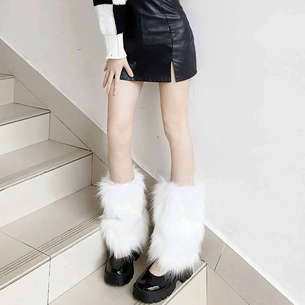 Woman wearing faux fur white leg warmers over black platform shoes and a black leather skirt