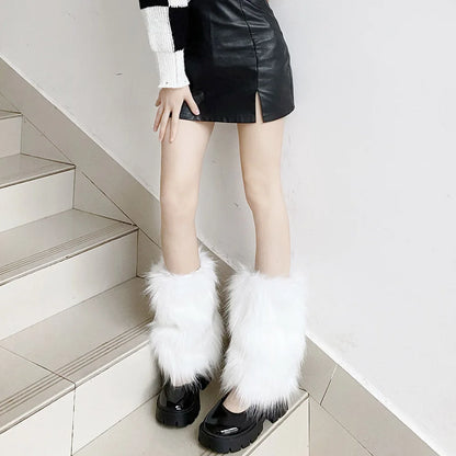 Woman wearing faux fur white leg warmers over black platform shoes and a black leather skirt