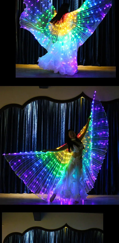 Woman performing on stage with large LED light-up wings and flowing white costume