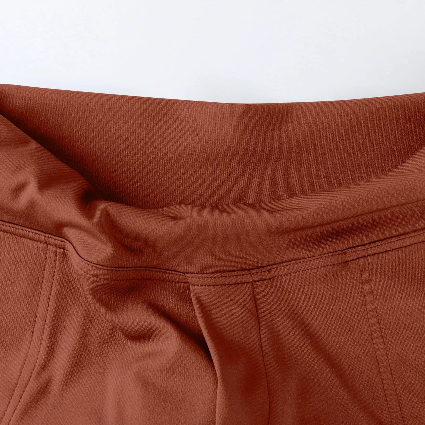 Close-up of high-waisted brown leggings with smooth fabric and visible seam stitching