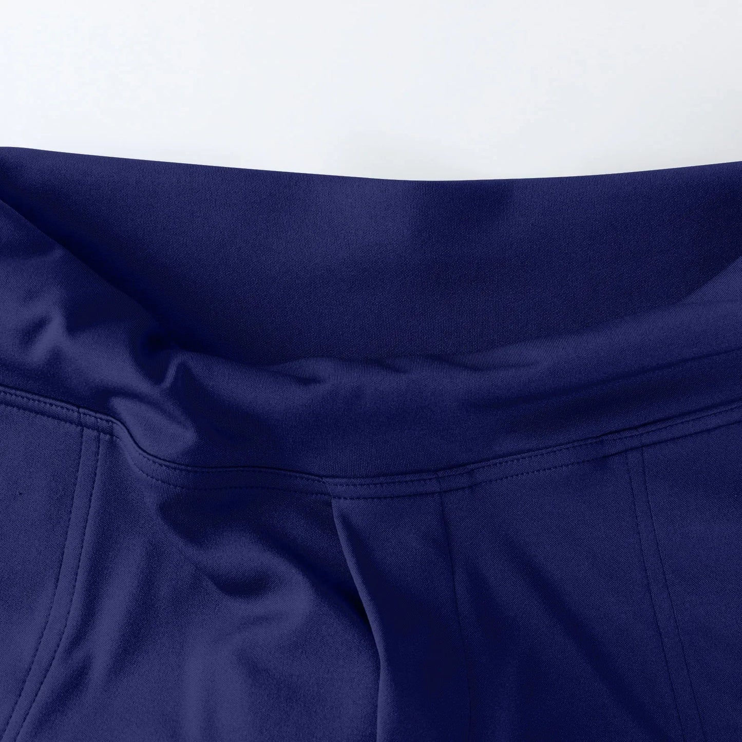 Close-up of blue athletic leggings waistband with smooth fabric and detailed stitching