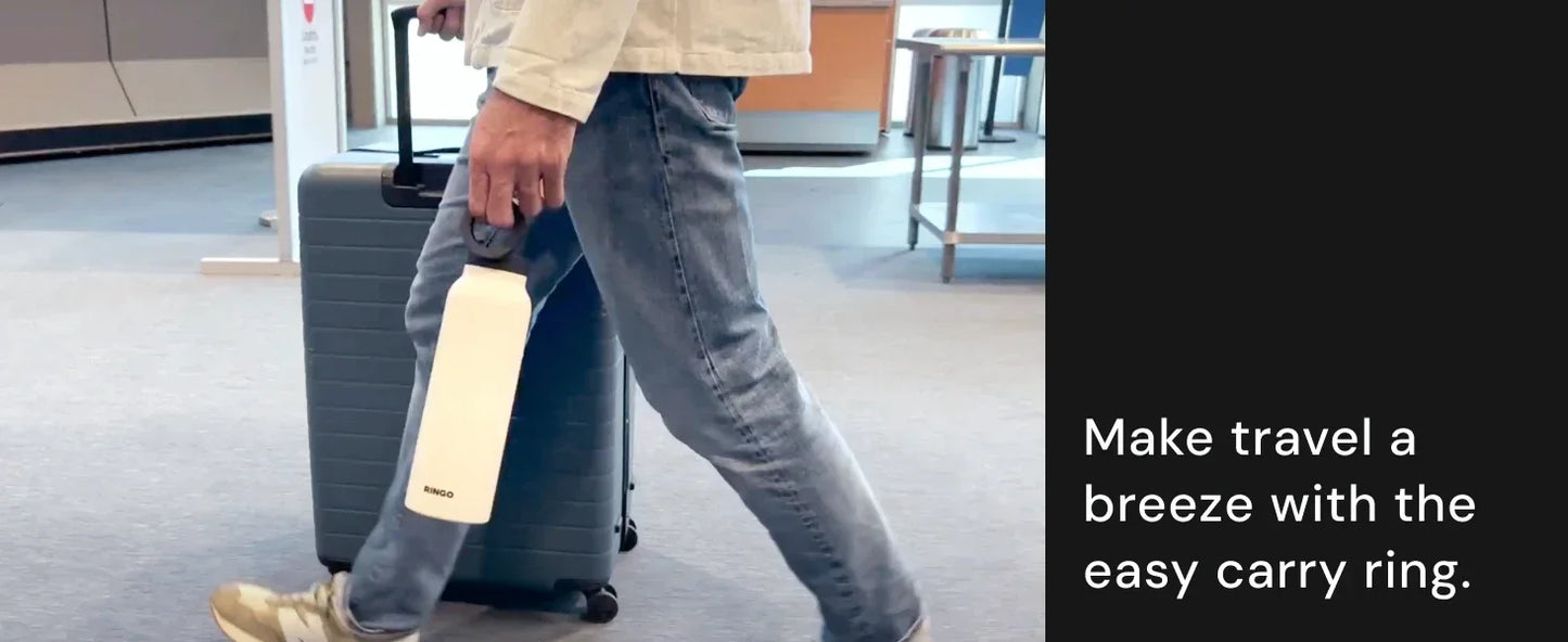 Traveler pulling suitcase and carrying white bottle with handle ring in airport for easy transport.