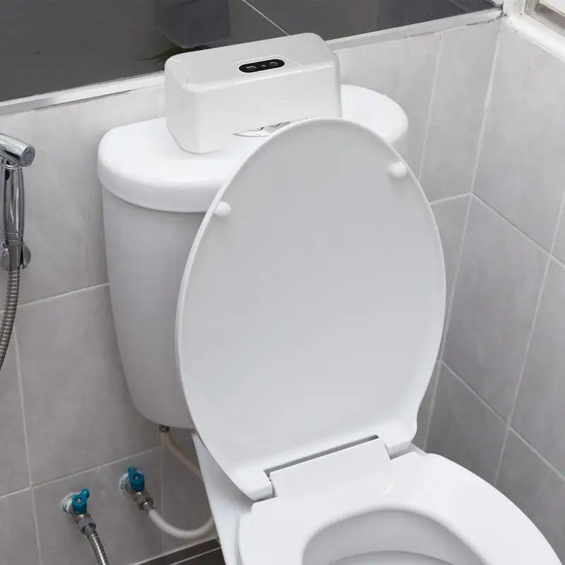 White toilet with an automatic wipe dispenser on the tank in a modern bathroom